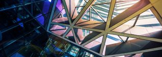 Modern glass office building wide angle view looking up